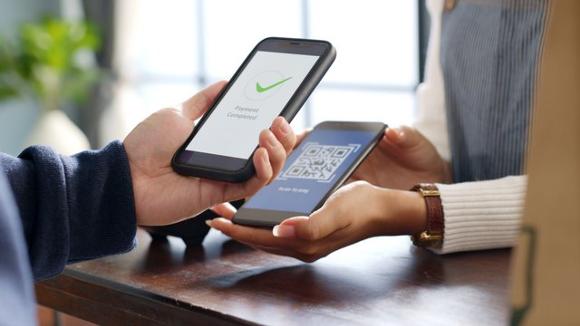 cashless tipping in UK. Phone scanning a qr code.